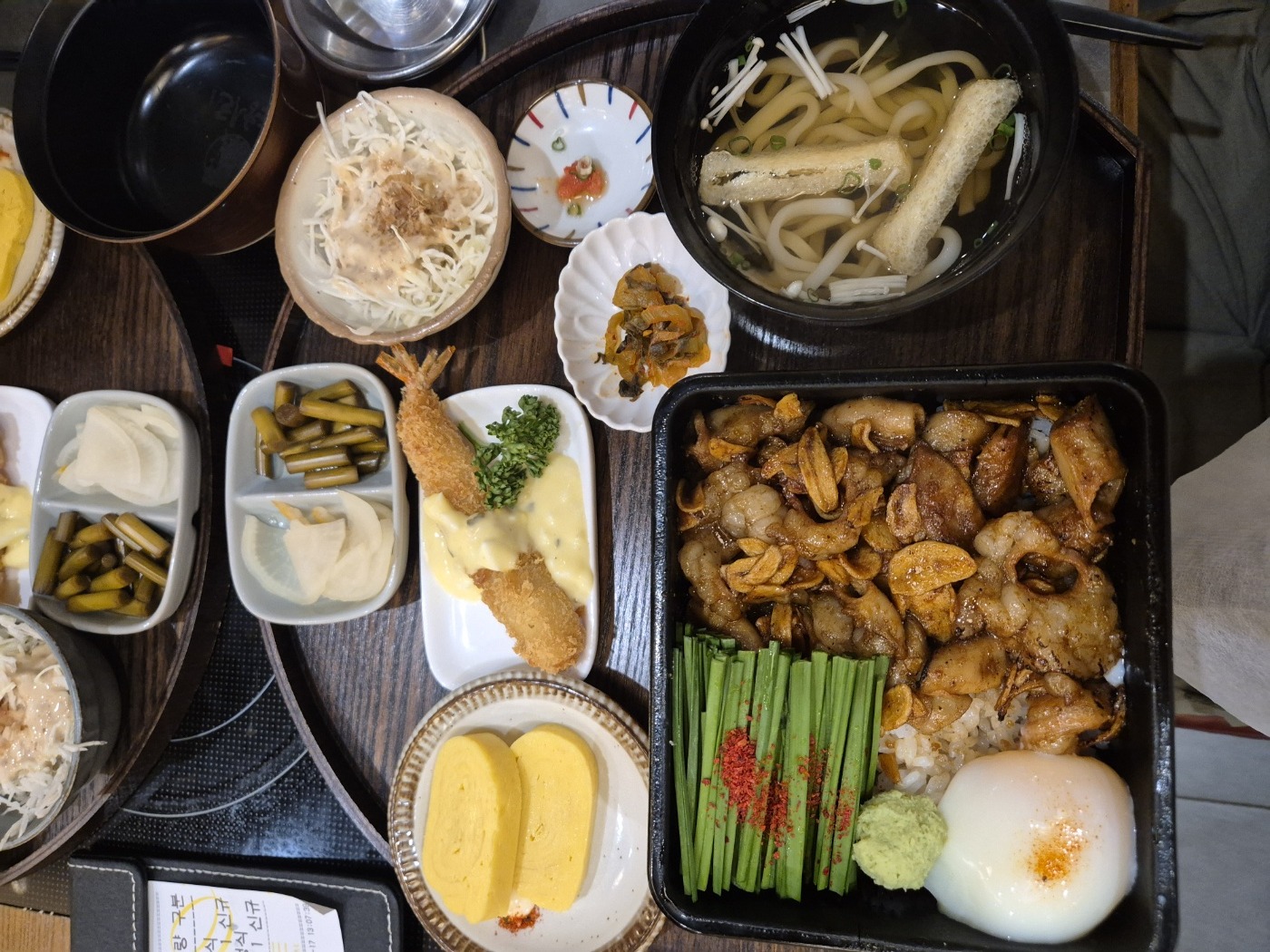대창곱창구이 정식 — 대창과 곱창이 올라간 덮밥에 반숙 달걀, 쪽파, 와사비와 우동, 새우튀김, 달걀말이 사이드가 함께 나온 모습
