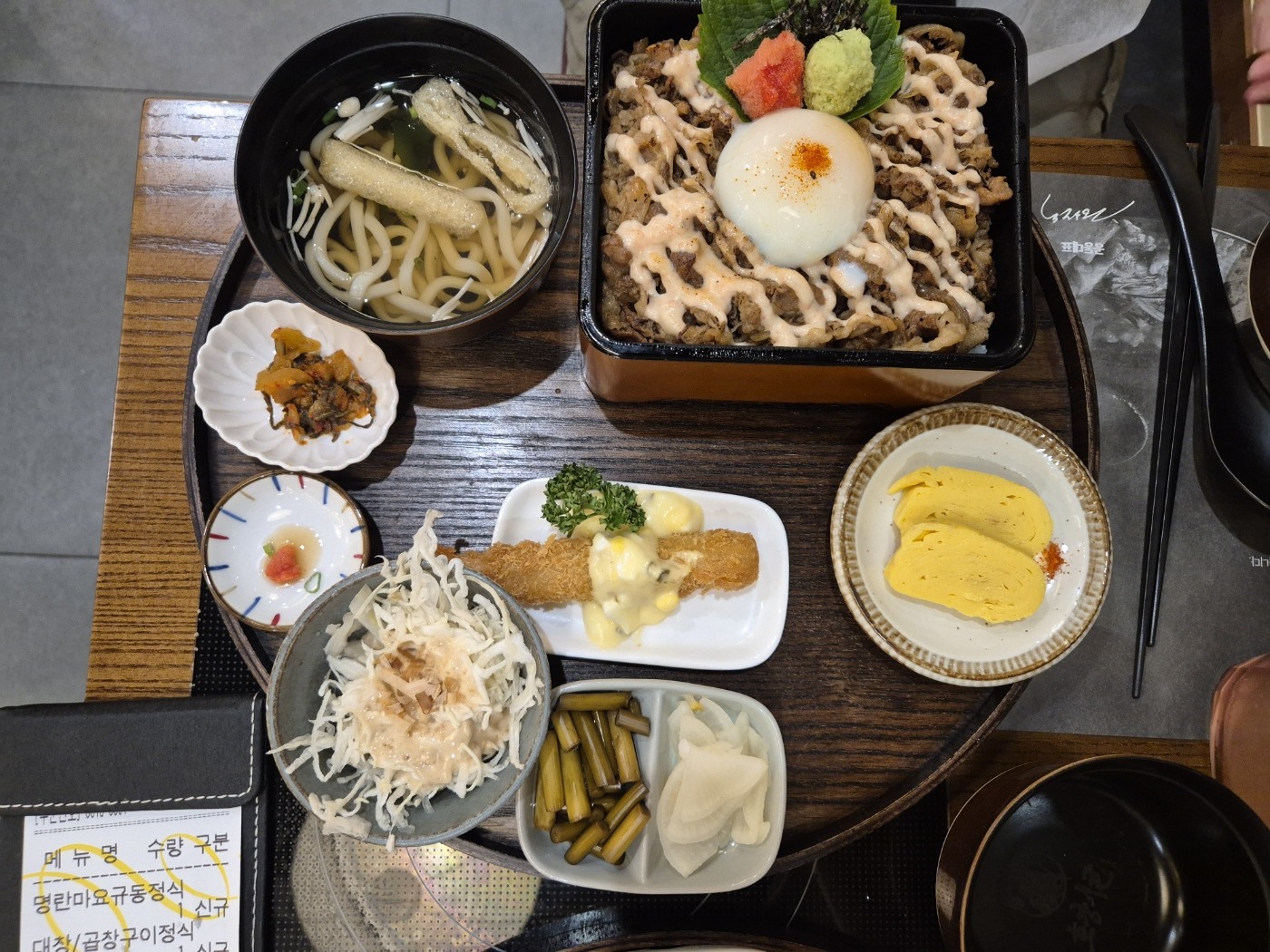 명란마요 규동 정식 — 명란마요 소스가 격자로 뿌려진 규동에 반숙 달걀, 우동, 새우튀김 사이드가 함께 나온 모습
